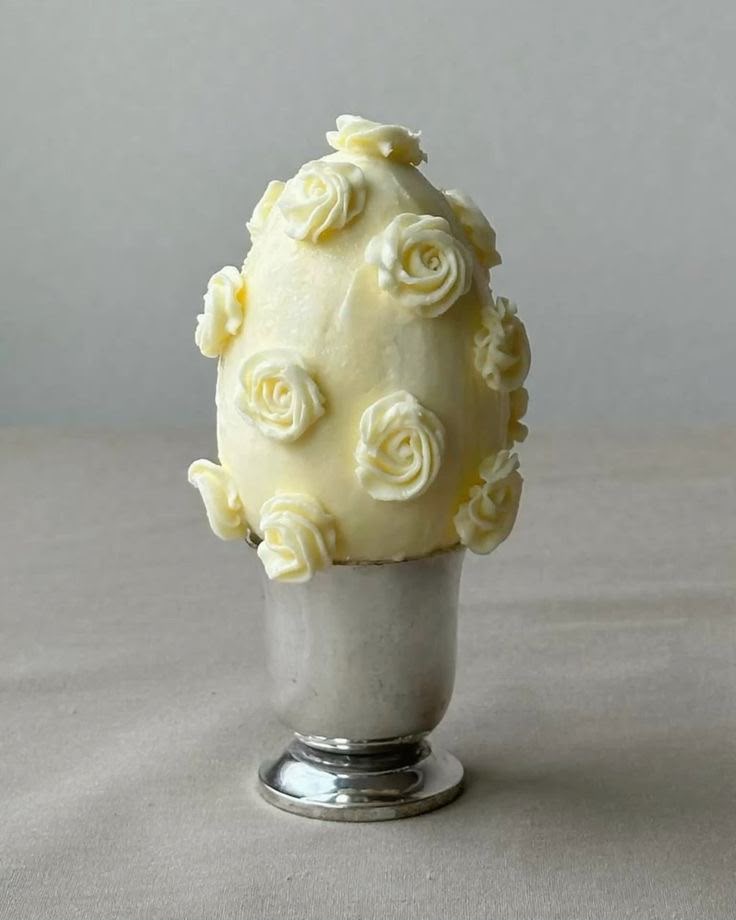 Escultura de buttercream con rosas sobre copa metálica